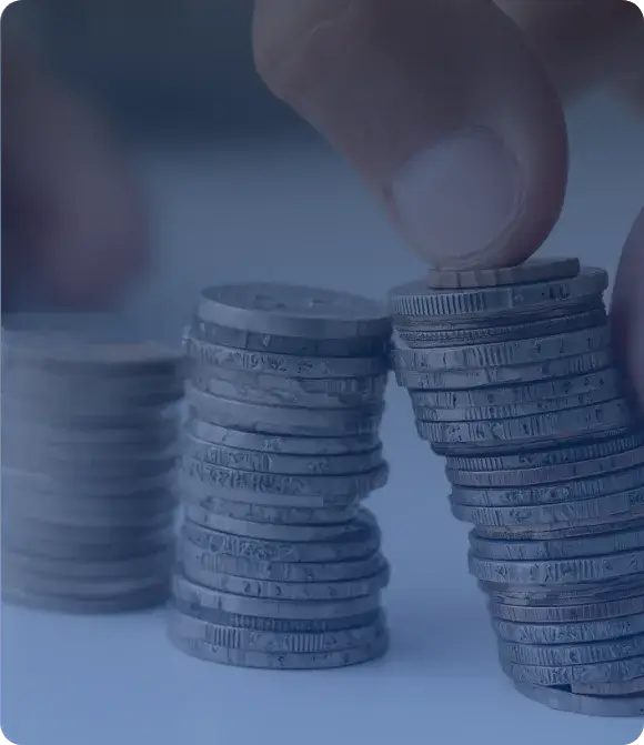 Hand stacking coins into neat piles on a smooth surface, suggesting careful financial planning and savings. The background is softly blurred, creating a calm and focused atmosphere. The overall tone is reassuring and optimistic.
